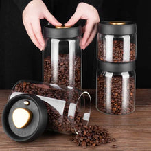 Load image into Gallery viewer, Vacuum sealed glass canisters with black lids storing coffee beans.
